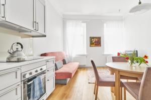 cocina y sala de estar con mesa y sofá en New and Lovely Apartament in Vilnius City Centre en Vilna