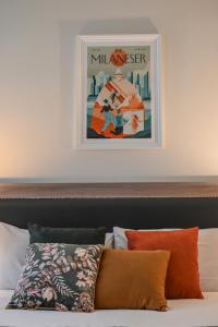 a bed with pillows and a picture on the wall at Hotel Zara Milano in Milan