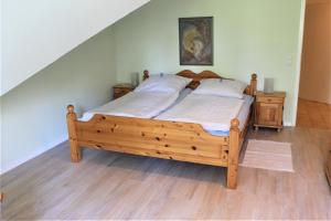 a bedroom with a wooden bed with two night stands at "Pappelhof - Whg 5" in Grömitz