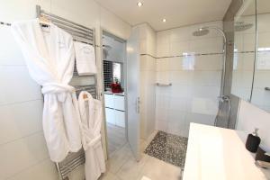 a bathroom with a shower and white towels on a rack at La Maison de Jeanne in Sélestat +9 photos