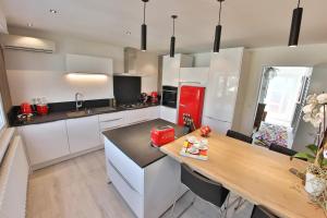 a kitchen with white cabinets and a red refrigerator at La Maison de Jeanne in Sélestat