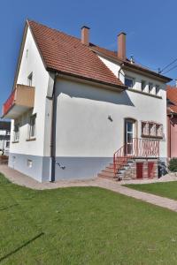 une maison blanche avec un toit rouge dans l'établissement La Maison de Jeanne, à Sélestat