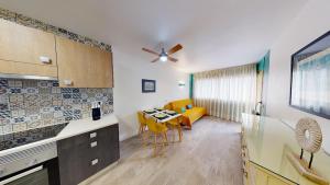 a kitchen with a table and yellow chairs in a room at Apartamentos Eldorado in Lloret de Mar