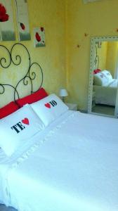 1 dormitorio con 1 cama con sábanas blancas y espejo en Gaia's Room B&B, en Roma