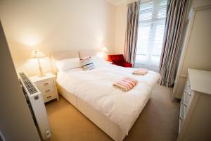a bedroom with a white bed with two towels on it at Tudor Villas Apartment, Cromer in Cromer