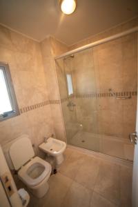
a bathroom with a toilet a sink and a shower at Hotel Estilo MB - Villa Carlos Paz in Villa Carlos Paz
