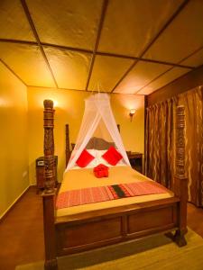 a bedroom with a bed with a canopy at Ombak Dive Resort Perhentian Island in Perhentian Islands