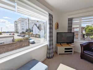 a living room with a tv and a large window at The Lookout - Bognor Regis in Bognor Regis