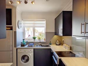 uma cozinha com uma máquina de lavar roupa e um lavatório em The Lookout - Bognor Regis em Bognor Regis