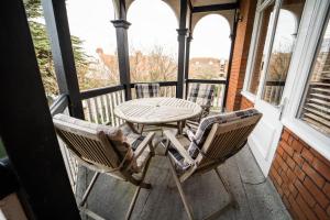 - une table et des chaises en bois sur une terrasse couverte avec une table et des chaises dans l'établissement Tudor Villas Apartment, Cromer, à Cromer