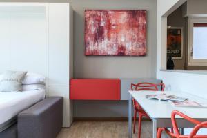 ein Wohnzimmer mit einem Sofa, einem Tisch und einem Gemälde in der Unterkunft Contempora Apartments - Elvezia 8 - E33 in Mailand