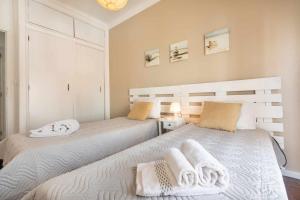2 letti in una camera da letto con asciugamani di T2 Apartamento do Tenis ad Albufeira
