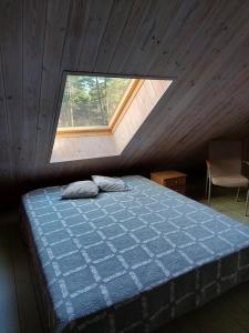 a bedroom with a bed in a attic with a window at Ratsu Turismitalu in Jõgela