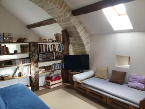 a living room with a couch and a tv at Gîte La Grange in Saint-Laurent-dʼOlt