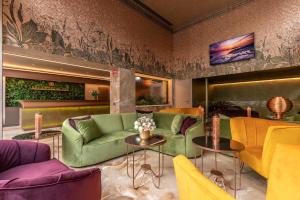 salon z zielonymi kanapami i stołami w obiekcie Hotel Ariston w Mediolanie