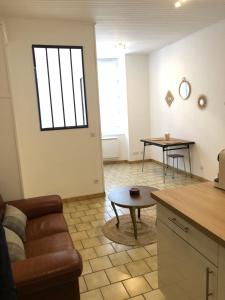 een woonkamer met een bank en een tafel bij Joli appartement au coeur de ville in Château-Thierry