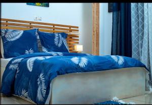 a bed with blue comforter and blue pillows at Appartement cosy 4 bonapriso in Douala