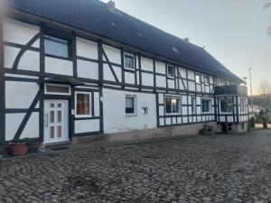 a black and white building with a cobblestone street at Fewo Wolf in Einbeck