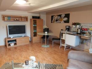 ein Wohnzimmer mit Fernseher und Tisch in der Unterkunft Fewo Wolf in Einbeck