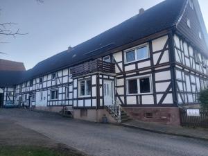 un gran edificio blanco y negro con porche en Fewo Wolf, en Einbeck