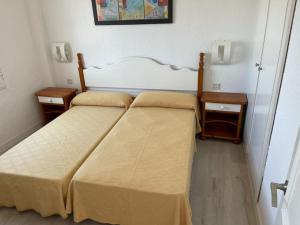 a bedroom with two beds and two night stands at Apartamento CastellSol 102 in Arenal d'en Castell