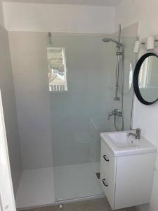 een witte badkamer met een wastafel en een spiegel bij Apartamento CastellSol 102 in Arenal d'en Castell
