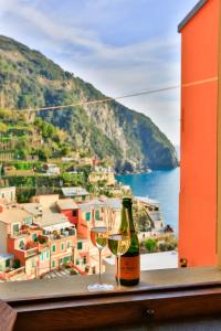 a bottle of wine and two glasses on a ledge at Perla del Marinaio in Riomaggiore