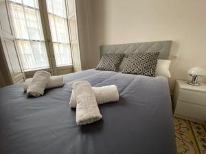 馬拉加的住宿－Sweet Home Museo Thyssen，一间卧室配有一张床,上面有两条毛巾