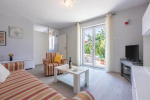 ein Wohnzimmer mit einem Sofa, einem Tisch und einem TV in der Unterkunft House Milenka in Banjol