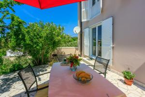 einen Tisch mit einer Obstschale auf einer Terrasse in der Unterkunft House Milenka in Banjol