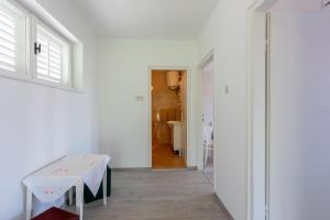 ein weißes Zimmer mit einem Tisch und einem Flur in der Unterkunft House Milenka in Banjol