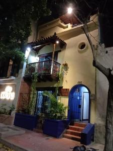 a house with a blue door and a balcony at night at hospedaje luna azul in Santa Marta