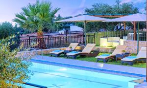 basen z leżakami i parasolami obok ośrodka w obiekcie Villa Stelios Private Pool w mieście Georgioupolis