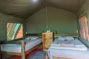 En eller flere senger på et rom på Tana Safaris Bush Camp