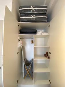 a small closet with white shelves and a chair at The Opal Suite Troika Kota Bharu 1 Bedroom in Kota Bharu +6 photos