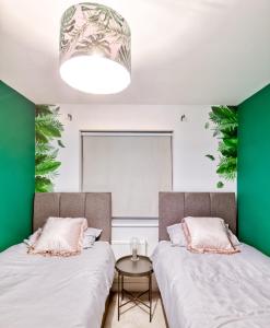 2 łóżka w pokoju z zielonymi ścianami w obiekcie 5 Bed House in Gloucester w mieście Hucclecote