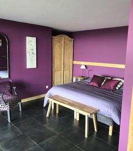 Lissac et MouretにあるTravers de Pechméjàの紫の壁のベッドルーム(ベッド1台、ベンチ付)