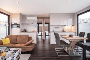 een keuken en een woonkamer met een bank en een tafel bij Houseboat 'Elysium' met eigen aanlegsteiger Sneek - Offingawier in Offingawier