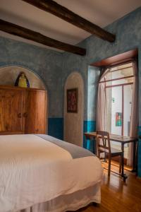 a bedroom with a bed and a desk and a chair at La Casa de Manuel Casa-Boutique in Loja