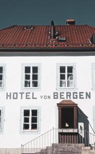 ein weißes Gebäude mit einem Schild, das Hotel van berliner liest in der Unterkunft Hôtel Von Bergen in La Sagne