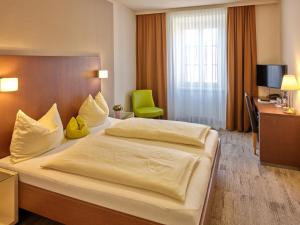 una camera d'albergo con un grande letto e una scrivania di Stadthotel Schärding a Schärding