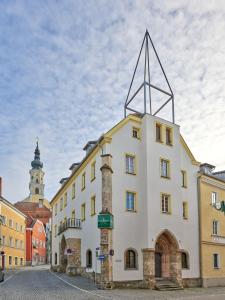 a white building with a cross on the top of it at Stadthotel Schärding in Schärding