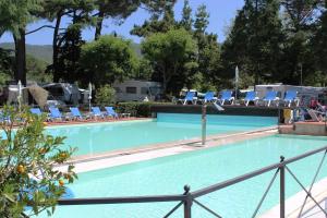 une grande piscine bleue avec des chaises longues dans l'établissement Hotel Kursaal, à Passignano sul Trasimeno