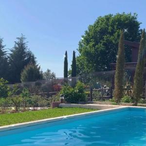 a swimming pool in the yard of a house with trees at CAMPO DE SOBARBO - Guest House rural in Penafiel