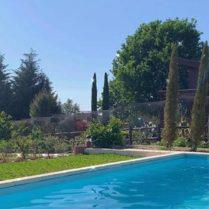 una piscina en el patio de una casa con árboles en CAMPO DE SOBARBO - Guest House rural, en Penafiel