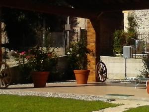 un patio con macetas y una mesa en B&B Gigetto, en Pescantina
