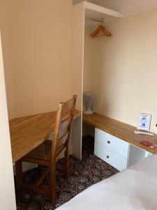 a desk and chair in a room with a bed at Bouvrie Guest House in Hereford
