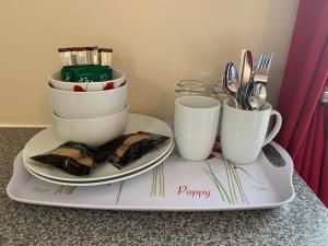 a tray with two plates and cups on a counter at Bouvrie Guest House in Hereford