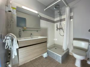 a white bathroom with a sink and a toilet at HOTEL DE LA GARE in Eygliers