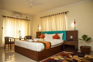 a bedroom with a large bed and a table and chairs at Gautam Buddha Airport Hotel in Bhairāhawā